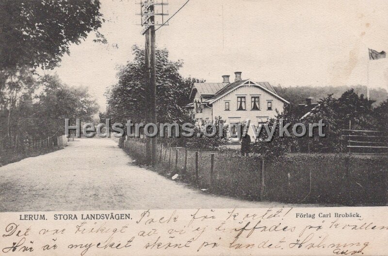 Lerum. Stora landsvagen. Postganget 22 augusti 1903. Forlag Carl Broback.jpg - Lerum. Stora landsvägen.Postgånget 22 augusti 1903.Förlag Carl Brobäck.Förlag Carl Brobäck.Stora landsvägen från Göteborg in i Lerum. Byggnaden är pensionatet och det ser ut som att det är unionsflaggan som är hissad.